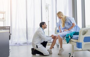 Lekarz bada kolano u pacjentki